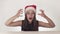 Beautiful happy girl teenager in a Santa Claus hat emotionally expresses a joyful surprise on white background stock