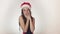 Beautiful happy girl teenager in a Santa Claus hat emotionally imagining and posing on white background stock footage