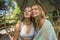 Beautiful and happy girlfriends after outdoors yoga workout - two young pretty women smiling cheerful enjoying tropical jungle