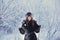 Beautiful happy laughing young woman wearing winter hat gloves covered with snow flakes.