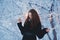 Beautiful happy laughing young woman wearing winter hat gloves covered with snow flakes.