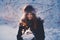 Beautiful happy laughing young woman wearing winter hat gloves covered with snow flakes.