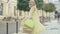 Beautiful happy mid-adult woman in yellow dress spinning with shopping bags and leaving. Portrait of cheerful blond