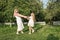 beautiful happy mother and daughter holding hands and twisting in garden