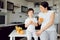 Beautiful happy mother pour orange juice to her child boy in kitchen