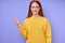 beautiful happy redhead woman in yellow stylish sweater demonstrating letter K