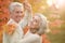 Beautiful happy senior couple with autumn leaves dancing