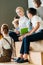 beautiful happy teacher sitting on wooden tribune with schoolchildren