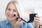 Beautiful happy woman engrossed in her makeup routine, with the mirror reflecting her poised and confident aura. Woman is doing