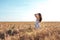 Beautiful happy woman field, sunny afternoon, white dress. Brunette hair, tanned skin, concept of enjoying nature. Happy