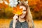 Beautiful happy woman with a smile holds an autumn yellow