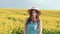 beautiful happy woman standing in flowering field. Yellow natural flowers rape.