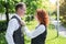 Beautiful and happy young couple in nature. Wife fixes her husband`s tie.