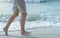 Beautiful healthy female legs jogging with barefoot alone on clean sandy sea beach in ocean in summer morning sunlight