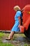 Beautiful healthy senior woman in a blue dress by a red truck