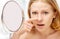 Beautiful healthy woman frightened saw in the mirror acne and wrinkles