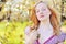 Beautiful healthy young girl in blooming tree. Eyes closed