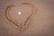 Beautiful heart symbol in beach sand with sea shell in middle. Focus set on seashell