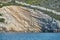 Beautiful high cliff with caves and hanging rocks of a mountain in Adriatic sea, a crevice, colorful