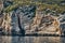 Beautiful high cliff with caves and hanging rocks of a mountain in Adriatic sea, a crevice, colorful