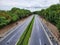 A beautiful highway between green trees .