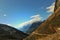 Beautiful hillscape  with valley and snowcapped mountains and blue  sky with a moutain road with cars