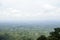 Beautiful hilly horizon drone shot with green meadow. Rural mountain top view with cloudy sky and green trees. Foggy and cloudy