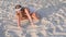 Beautiful hippie woman with bracelets and rings is touching sand on the beach