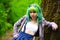 Beautiful hipster alternative young woman with green hair in park