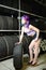 Beautiful hipster girl automobile mechanic works with tires on wheels