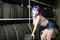 Beautiful hipster girl automobile mechanic works with tires on wheels