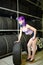 Beautiful hipster girl automobile mechanic works with tires on wheels