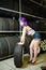 Beautiful hipster girl automobile mechanic works with tires on wheels