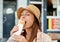 Beautiful Hispanic female in a hat eating a burrito in a cafe on a sunny day