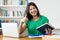 Beautiful hispanic female student preparing for exam at desk