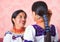 Beautiful hispanic mother and daughter wearing traditional andean clothing, seen from profile angle facing each other