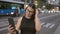 Beautiful hispanic woman donning glasses, enjoying a fun selfie moment in urban madrid, showcasing a positive, confident smile