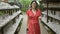 Beautiful hispanic woman in glasses counting on luck, standing by the famous lucky cat statue at gotokuji temple in tokyo