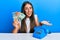 Beautiful hispanic woman with vintage telephone holding australian dollars celebrating achievement with happy smile and winner