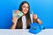 Beautiful hispanic woman with vintage telephone holding australian dollars smiling with an idea or question pointing finger with