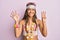 Beautiful hispanic woman wearing bohemian and hippie style showing and pointing up with fingers number eight while smiling