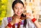 Beautiful hispanic woman wearing white blouse with colorful embroidery, using small hairbrush during makeup routine