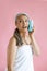 Beautiful hoary haired Asian woman uses bath sponge as mobile phone on pink background