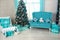 Beautiful holdiay decorated room with Christmas tree with presents under it. light blue, turquoise and white interior shades with