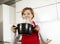 Beautiful home cook woman at kitchen holding spoon and cooking pot