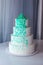 Beautiful home wedding four-tiered cake decorated with turquoise flowers on white table