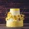 Beautiful home yellow wedding three-tiered cake decorated with red spring flowers. Concept floral trends in desserts