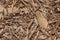Beautiful horizontal texture of brown bark and wood chips of conifer tree with knots and cracks for mulching of soil is