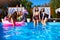 Beautiful hot pretty girls in bikini have fun in swimming pool on inflatable pink flamingo, swan floaties. Attractive