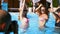 Beautiful hot pretty girls in bikini are photographed dancing with inflatable watermelon floaty at pool party. Pro